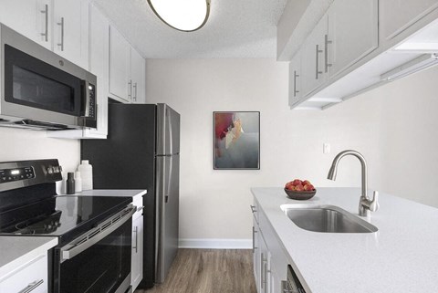 a kitchen with black appliances and white cabinets at Lakeside Villas, Florida